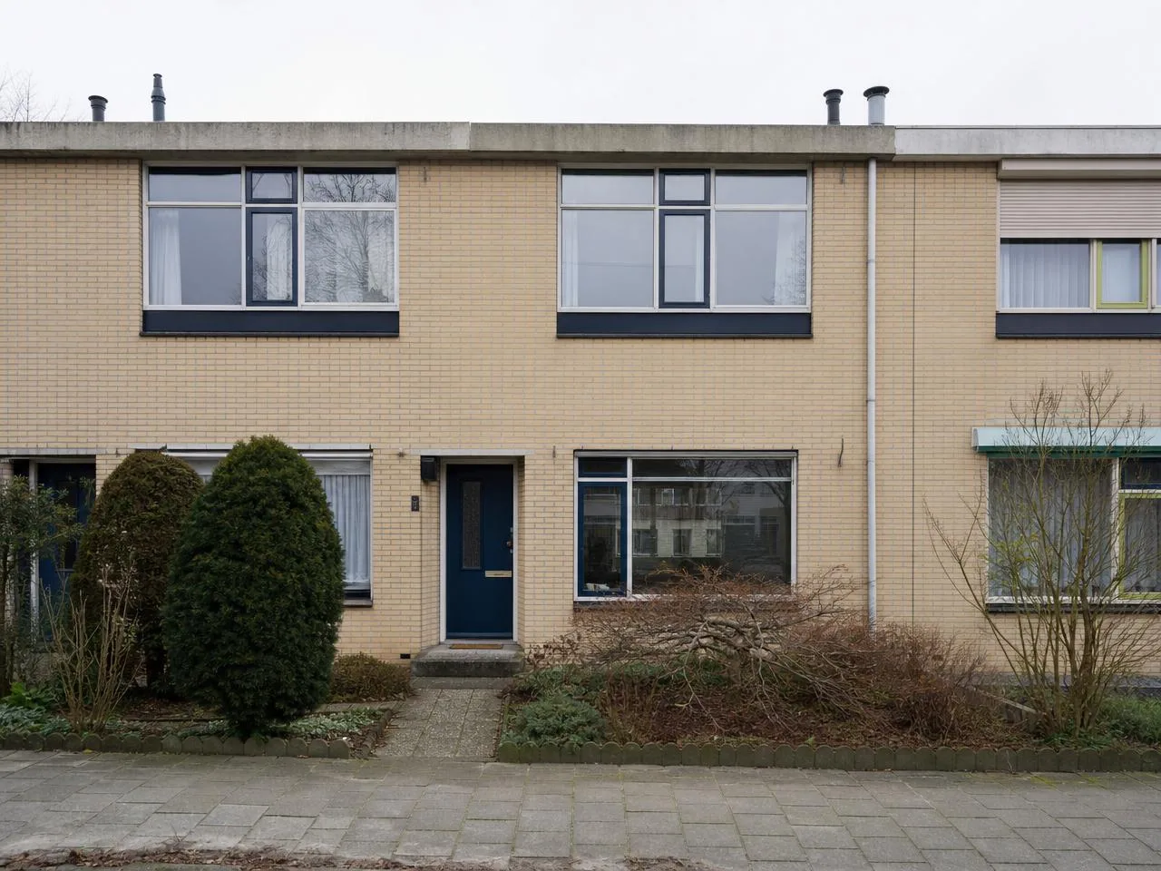 Jaren '60 rijtjeshuis Zwolle, lichte gele baksteen, plat dak